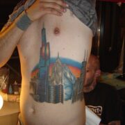 A man with tattoos on his stomach and chest.