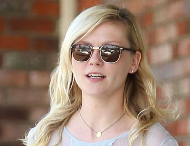 A woman wearing sunglasses and a necklace.