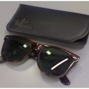 A pair of sunglasses sitting next to a case.