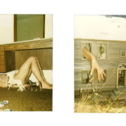 A woman laying on the ground next to a house.