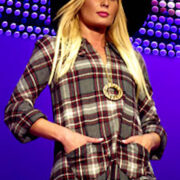 A woman in plaid shirt and hat on runway.