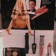 A display of cosmetics and makeup on top of a magazine.