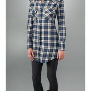 A person wearing black pants and a plaid shirt.