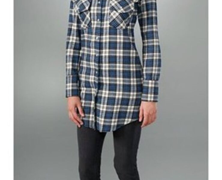 A person wearing black pants and a plaid shirt.