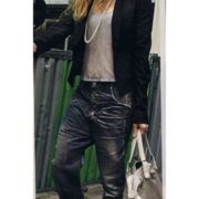 A woman in black jacket and leather pants.