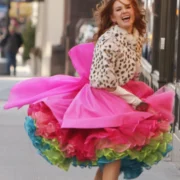 A woman in a pink dress and leopard print jacket.