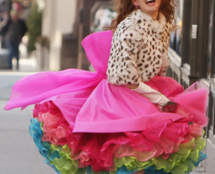 A woman in a pink dress and leopard print jacket.
