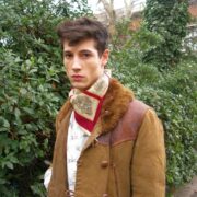A man in a brown jacket and red scarf.