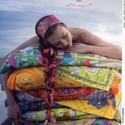 A woman laying on top of a pile of blankets.