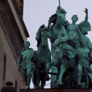 A statue of people on horses in front of a building.