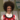 A woman with a big afro in front of some posters