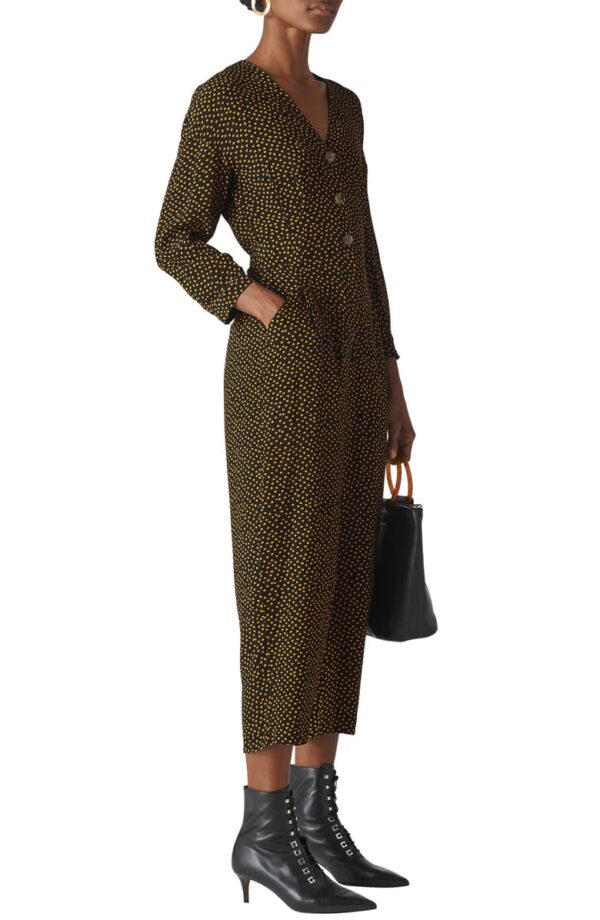 A woman in a long dress holding a purse.