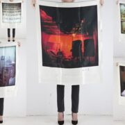 A person holding up a poster with pictures of buildings.